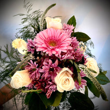 Bouquet of pink and white roses, pink gerbera daisies, and commercial mums with fresh seasonal greenery, arranged in a soft and cheerful style.